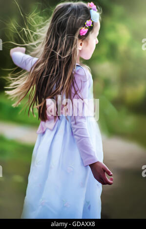 beautiful little girl in white dress dancing in nature Stock Photo