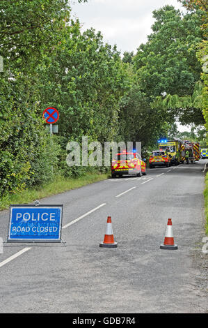 Scene of a road accident on a rural road in the UK. Emergency services attending.