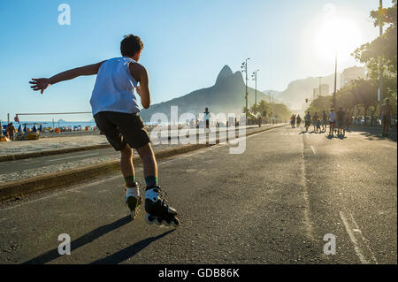 RIO DE JANEIRO - MARCH 6, 2016: Young carioca Brazilian man skates along the beachfront road on a car-free sunset on Ipanama. Stock Photo