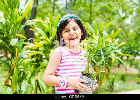1 indian Kid girl park Scissors Cutting Plant Stock Photo