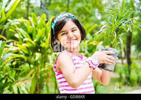1 indian Kid girl park holding Potted Plant Stock Photo