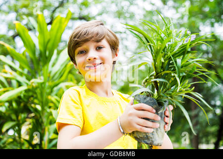 1 indian Kid boy park holding Potted Plant Stock Photo