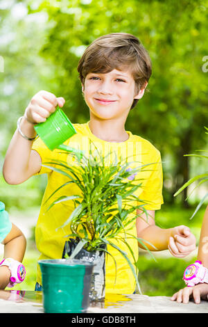 1 indian Kid boy park Watering Can Pouring Water Stock Photo