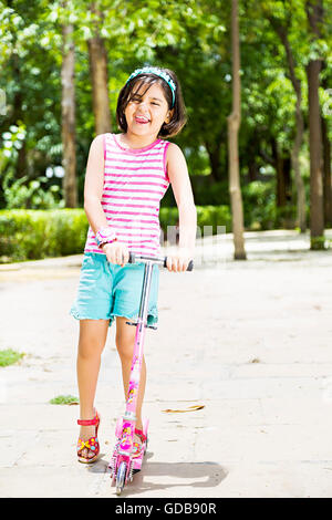 1 indian Kid girl park Push Scooter Riding Stock Photo