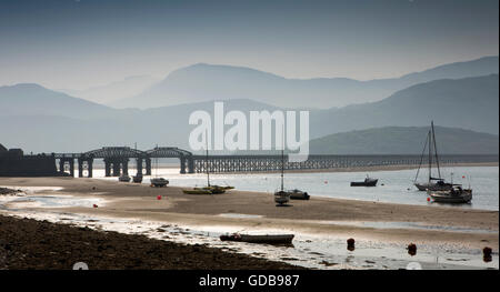 UK, Wales, Gwynedd, Barmouth, boats moored on Mawddach Estuary near Railway Viaduct at low tide Stock Photo