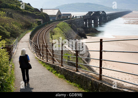 UK, Wales, Gwynedd, Barmouth, woman walker on path to on Mawddach Estuary viaduct Stock Photo