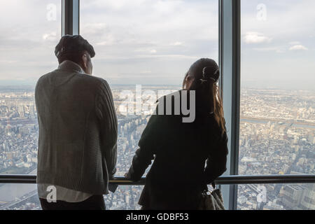 Japanese tourists look out over Tokyo from the Tokyo SkyTree, tallest tower in the world. Stock Photo