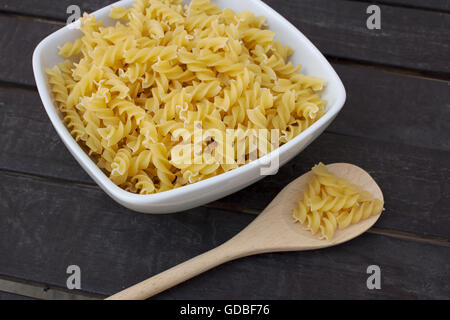 Selection of dried Italian fusilli pasta on wooden background Stock Photo