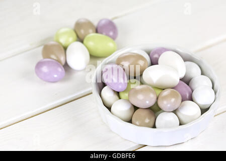 Colorful sugared almonds on wooden white background Stock Photo