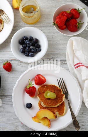 pancakes with fruits on white wooden table Stock Photo