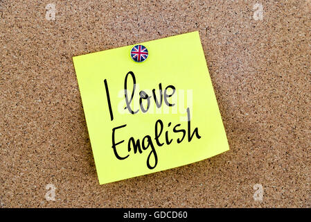 Yellow paper note pinned on cork board with Great Britain flag thumbtack, written text I love English Stock Photo