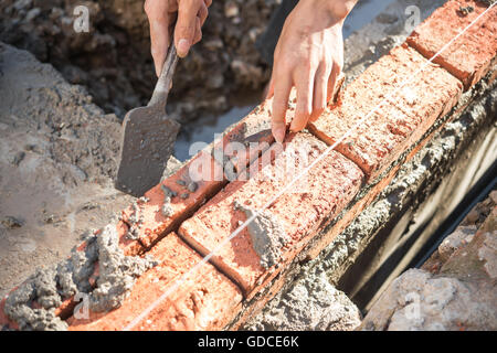 plasterer making up a brick wall with cement Stock Photo