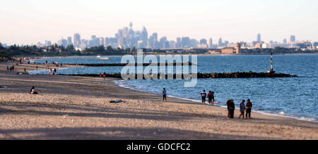 Sydney, Australia - Apr 21, 2014. People relaxing at Brighton le Sands beach on Easter Monday. Sydney city view in the backgroun Stock Photo