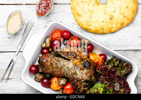 Twisted meatloaf with veal in plum sauce and vegetables in baking dish Stock Photo