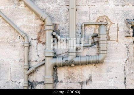 Sewer pipes on the stone facade of a  building Stock Photo