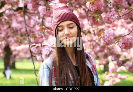 Happy beautiful young teenage girl in blossom park Stock Photo