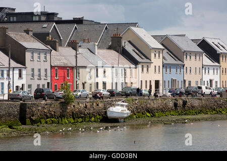 Ireland, Co Galway, Galway, boat beside colourfully painted Long Walk houses at low tide Stock Photo