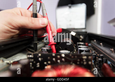 Tech tests electronic equipment in service center Stock Photo