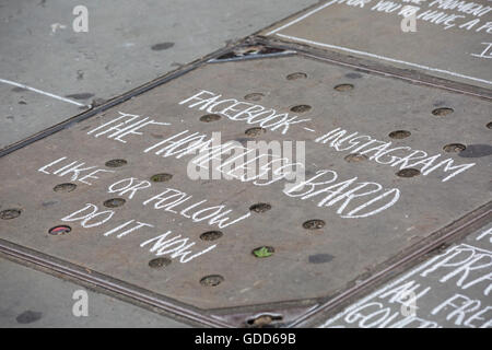 Street artist writing poems in chalk at Trafalgar Square, London in July Stock Photo