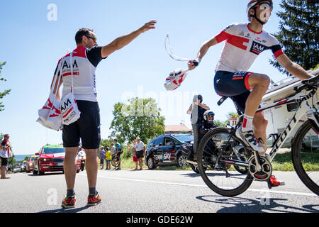 Revel-Tourdan, France. 16th July, 2016. An IAM Cycling team soigneur successfully hands off a musette bag. Each musette contains food and drink for the riders. John Kavouris/Alamy Live News Stock Photo