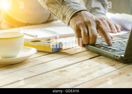 Young architects working his laptop with equipment construction on wooden table.1 Stock Photo