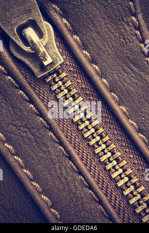 Macro of a closed zipper of leather bag. Vintage style. Vertical image. Stock Photo