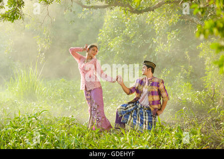 Man and woman in traditional clothing holding hands, Asia Stock Photo