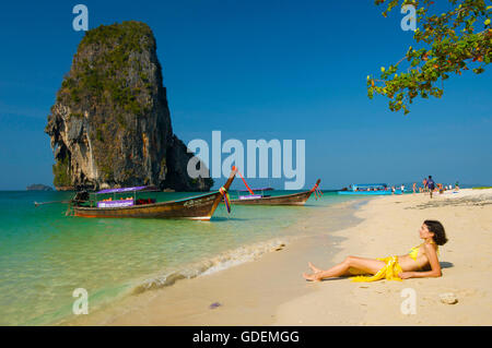 Woman relaxing on a long-tail boat at Laem Phra Nang Beach, Krabi, Thailand Stock Photo