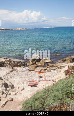Italy, Sardegna, Capo Testa,  Rena di Ponente, sunbather by the rocks. Stock Photo