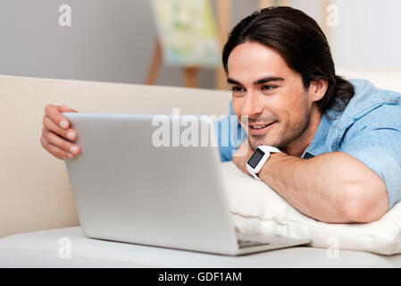 Positive bearded man using laptop Stock Photo