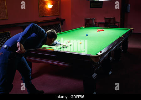 Playing pool, man aiming the billiard ball Stock Photo