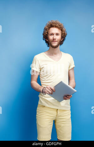 Young curly-haired man with tablet Stock Photo