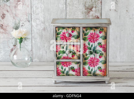 Handmade mini wardrobe decoupaged in a floral pattern on a shabby chic background Stock Photo