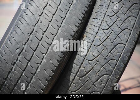 Used Tires. Stack of old used tires. Two damaged tires of private cars one on top of the other in the garage entrance. Stock Photo