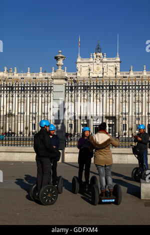 Asian tourists visiting the Royal Palace as part of a Segway tour, Plaza de la Armeria, Madrid, Spain Stock Photo