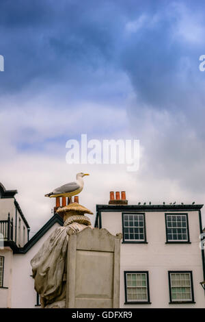 Seagull standing on statue head in Exeter Stock Photo