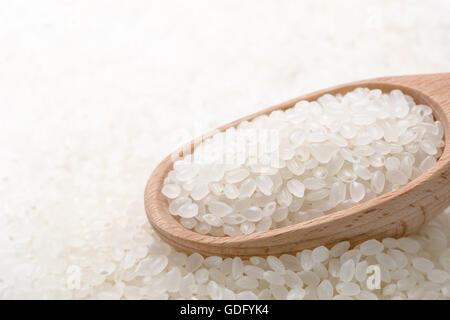 raw white rice in wooden spoon Stock Photo