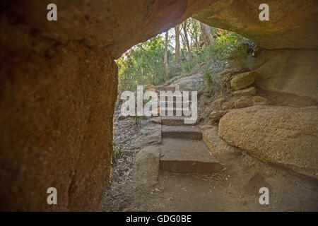 Stone steps through spectacular natural rock arch on walking track through forest in Goulburn River National Park, NSW Australia Stock Photo