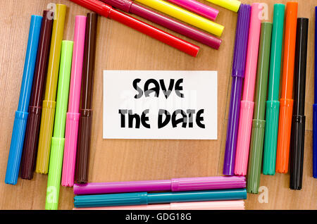 Save the date written on memo over wooden background Stock Photo