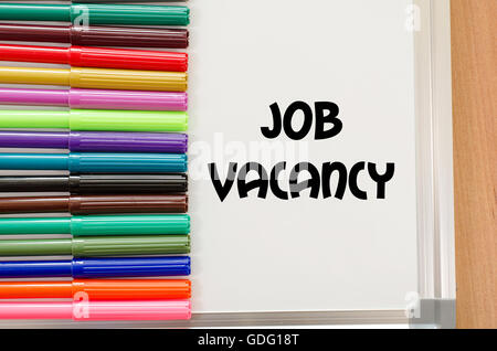 Job vacancy written on whiteboard over wooden background Stock Photo