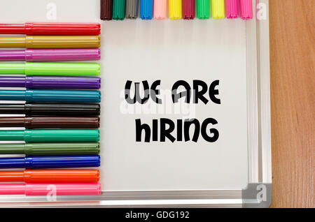 We are hiring written on whiteboard over wooden background Stock Photo