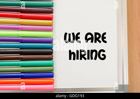 We are hiring written on whiteboard over wooden background Stock Photo