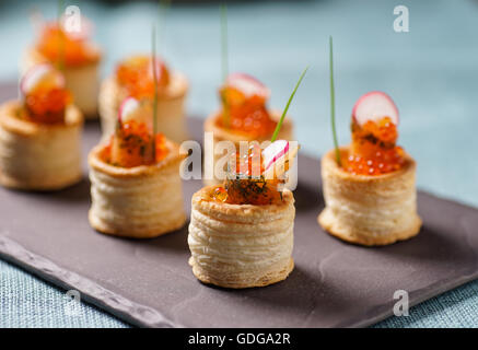 Delicious appetizers with graved salmon and golden caviar served in puff pastry towers Stock Photo