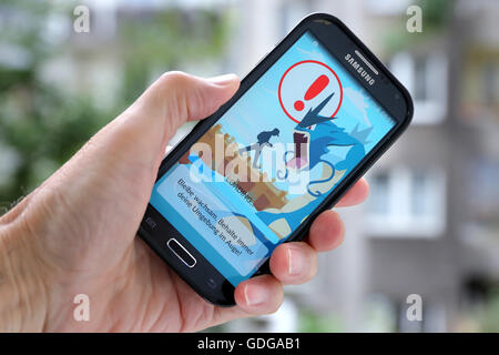 German version of the latest Nintendo game 'Pokémon go' on a Samsung smartphone. The caution advises players to be aware of the surroundings while playing Pokemon Go. Dortmund, Germany, July 17th.2016 Stock Photo