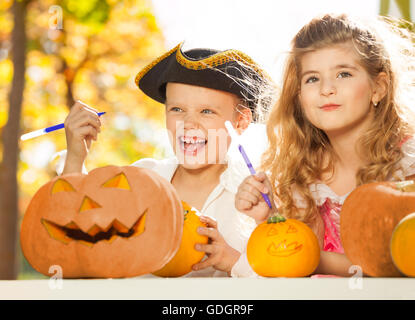 Boy and girl during Halloween crafting pumpkins Stock Photo