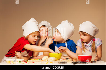 Cute kids tasting dough for handmade cookies Stock Photo