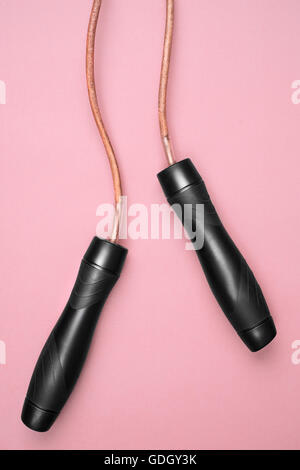 close-up wooden handles of skipping rope isolated on pink background Stock Photo