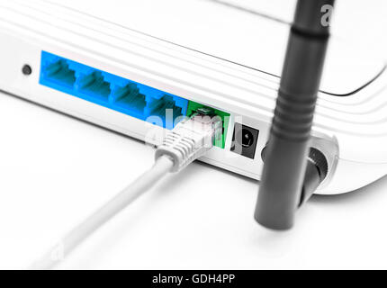 Network cable connected to wifi router on white background. Stock Photo