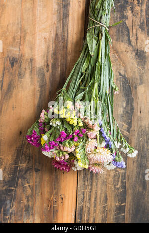Bouquet of Flowers, Statice and Strawflower ( Limonium Sinuatum and Helichrysum Bracteatum ) which Hangs and is Drying. Stock Photo