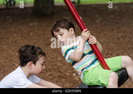 A couple of young brothers play together in the park. Stock Photo